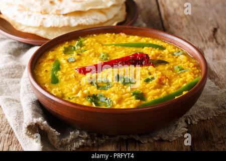 Köstliche Dal Tadka Rezept der gelbe Linsen mit Gewürzen, Kräutern und Chili close-up in einer Schüssel auf dem Tisch. Horizontale Stockfoto