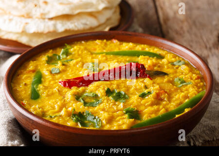 Dal Tadka traditionelle indische Küche aus gelben Linsen mit Gewürzen und Kräutern aus der Nähe in einer Schüssel auf den Tisch. Horizontale Stockfoto