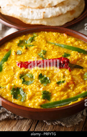 Indische beliebte Speisen Dal Tadka curry serviert mit Roti Fladenbrot close-up auf den Tisch. Vertikale Stockfoto