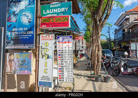 Kuta, Indonesien - 14. September 2018: Reihen von Business signages im Legian Street in Kuta. Legian ist berühmt unter Touristen für Nachtclub und unterha Stockfoto