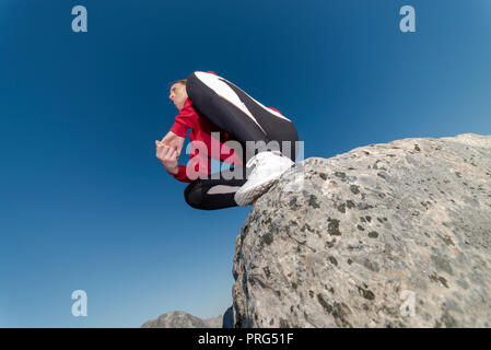 Frau sitzt auf einem Felsen boulder Nach dem Klettern Stockfoto