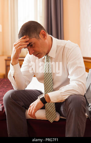Unternehmer sitzen im Hotel Zimmer und Denken Stockfoto