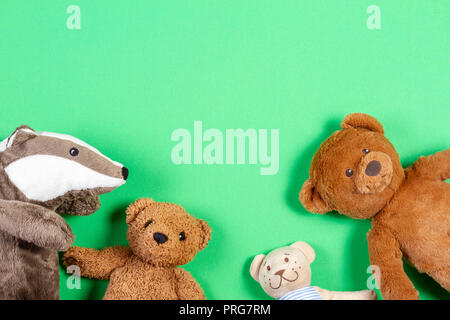 Baby Kinder Spielzeug Rahmen mit Teddybär und weich gefüllte baby Spielzeug auf grünem Hintergrund Stockfoto