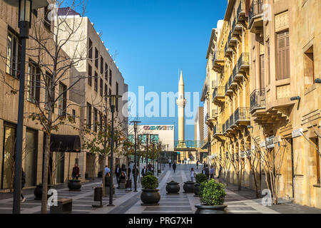Beirut, Libanon - Feb 5 2018 - Einheimische wandern in einem neuen, modernen Bereich der Beiruter Innenstadt in einem blauen Himmel Tag, Moschee minarete im Hintergrund. Stockfoto