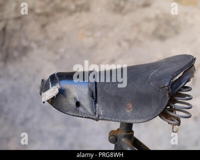 Alte leder Fahrrad Sattel, Sitz, mit sichtbaren Federn gerissen. Vintage Stockfoto