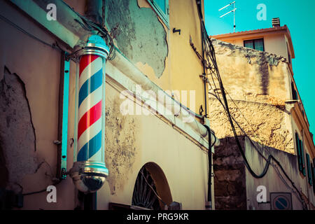 Alte Friseur mit Friseur- Pol in einer Gasse Stockfoto