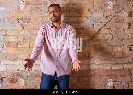 Porträt eines zornigen hübscher junger Mann, der in einem rosa Hemd. Stockfoto