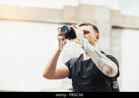 In der Nähe von attraktiven Mann, Fotos von modernes Gebäude. Stockfoto