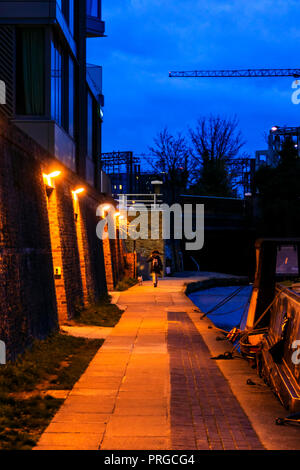 Junge Frau zu ihrem Hund nachts auf dem Leinpfad des Regent's Canal in King's Cross, London, UK Stockfoto