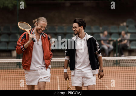 Lächelnd im Retrostil Tennisspieler wandern mit rackets am Tennisplatz Stockfoto