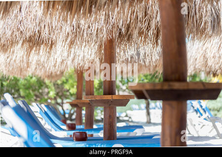 Sonnenschirme aus Holz mit Reetdach Stroh Dach in einer exotischen Caribbean Beach Resort an der Riviera Maya in Mexiko Yucantan Stockfoto