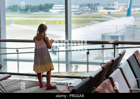 Kinder am Flughafen. Kinder im Flugzeug. Reisen und fliegen mit Kind. Familie an der Ausfahrtschranke. Urlaub und Reisen mit jungen Zicklein. Kleines Mädchen Stockfoto