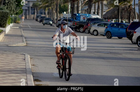 Deerfield Beach, Florida, USA. 2. Okt, 2018. Resident Leon Smith reitet seine Beach Cruiser das Tragen einer Staubmaske. Red Tide hat an der Ostküste von Florida und Deerfield Beach bestätigt wurde veröffentlicht eine Bekanntmachung, dass die offshore Wasser geprüft werden. Credit: Joe Cavaretta/Sonne-hinweissymbol/ZUMA Draht/Alamy leben Nachrichten Stockfoto