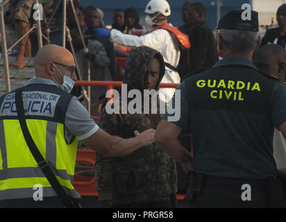 Malaga, Malaga, Spanien. 2. Okt, 2018. Ein Wanderarbeitnehmer aus gesehen Blick auf einen Polizisten, als er wartet in einem Zelt des spanischen Roten Kreuzes zu erhalten nach seiner Ankunft im Hafen von Málaga in Spanien Maritime Rescue Service 63 Migranten an Bord Segeln im Mittelmeer gerettet, und brachte sie nach Malaga Hafen, wo sie durch das Spanische Rote Kreuz unterstützt wurden. Mehr als 500 Migranten haben an einem Tag gerettet worden. Nach Angaben der spanischen Gemeinnützige''˜ Caminando Fronteras" (Grenzen), 32 Migranten und zwei Kinder sind gestorben oder am Meer verschwunden, während sie versuchen, die Marokkanische Küste zu verlassen Stockfoto