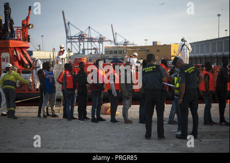 Malaga, Malaga, Spanien. 2. Okt, 2018. Eine Gruppe von Migranten in eine Warteschlange gesehen warten in einem Zelt des spanischen Roten Kreuzes nach Ihrer Ankunft im Hafen von Málaga in Spanien Maritime Rescue Service 63 Migranten an Bord Segeln im Mittelmeer gerettet, und brachte sie nach Malaga Hafen, wo sie durch das Spanische Rote Kreuz unterstützt wurden. Mehr als 500 Migranten haben an einem Tag gerettet worden. Nach Angaben der spanischen Gemeinnützige''˜ Caminando Fronteras" (Grenzen), 32 Migranten und zwei Kinder sind gestorben oder am Meer verschwunden, während sie versuchen, die Marokkanische Küste in Richtung zu verlassen Stockfoto