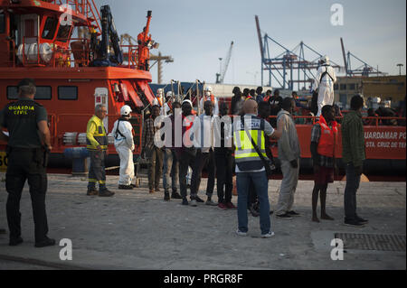 Malaga, Malaga, Spanien. 2. Okt, 2018. Eine Gruppe von Migranten in eine Warteschlange gesehen warten in einem Zelt des spanischen Roten Kreuzes nach Ihrer Ankunft im Hafen von Málaga in Spanien Maritime Rescue Service 63 Migranten an Bord Segeln im Mittelmeer gerettet, und brachte sie nach Malaga Hafen, wo sie durch das Spanische Rote Kreuz unterstützt wurden. Mehr als 500 Migranten haben an einem Tag gerettet worden. Nach Angaben der spanischen Gemeinnützige''˜ Caminando Fronteras" (Grenzen), 32 Migranten und zwei Kinder sind gestorben oder am Meer verschwunden, während sie versuchen, die Marokkanische Küste in Richtung zu verlassen Stockfoto