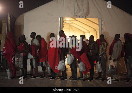 Malaga, Malaga, Spanien. 2. Okt, 2018. Migrantinnen und Migranten sind mit Taschen der Spanischen Roten Kreuz gesehen, da sie in eine Warteschlange zu leiten, für die Polizei van nach Ihrer Ankunft im Hafen von Málaga in Spanien Maritime Rescue Service 63 Migranten an Bord Segeln im Mittelmeer gerettet, und brachte sie nach Malaga Hafen, wo sie durch das Spanische Rote Kreuz unterstützt wurden, die übertragen werden sollen. Mehr als 500 Migranten haben an einem Tag gerettet worden. Nach Angaben der spanischen Gemeinnützige''˜ Caminando Fronteras" (Grenzen), 32 Migranten und zwei Kinder sind gestorben oder am Meer verschwunden, bei dem Versuch, sie zu verlassen. Stockfoto