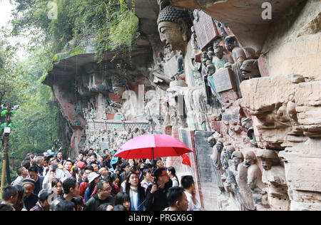 (181003) - chongqing, Oktober 3, 2018 (Xinhua) - Touristen Ansicht felszeichnungen am Kaiserhof Felszeichnungen Scenic Area in Günzburg Bezirk, im Südwesten Chinas Chongqing Gemeinde, Oktober 2, 2018. Ab 1. Oktober 2018, Touristen sind in der Lage, Chongqing Raufoss Felszeichnungen malerische Umgebung für niedrigere Eintrittspreise zu besuchen. Die schnitzereien Datum vom 9. bis 13. Jahrhundert und waren auf der Liste des Weltkulturerbes von der UNESCO im Jahre 1999 gelegt. (Xinhua / Wang Quanchao) (Gni) Stockfoto