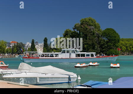 Paddel Boote und Fähren auf das klare, türkisfarbene Wasser des Sees Annecy Frankreich Stockfoto