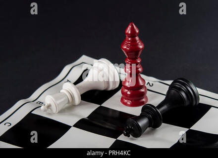 Drei Könige Schach vor jedem anderen, weißen und schwarzen Könige gefallen, rote König steht zwischen Ihnen steht. Neue Player auf den Boden. Strategie, f Stockfoto