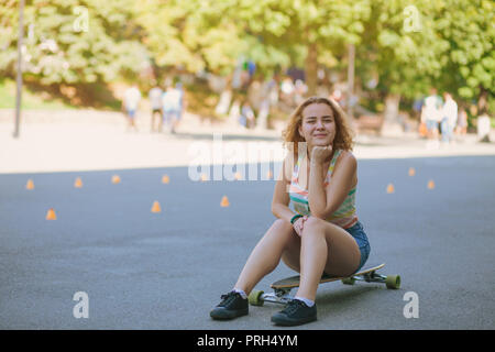 Das Sitzen auf einem Skateboard Stockfoto