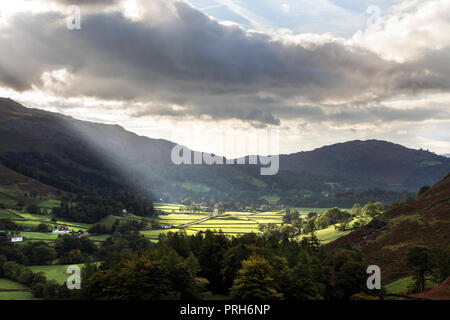 Sonnenstrahlen erhellt die Felder in der Umgebung des Dorfes Grasmere, Lake District, Cumbria, Großbritannien Stockfoto