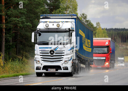 Salo, Finnland - 28 September, 2018: Die weissen und roten Mercedes-Benz DAF Fracht halb LKW-Verkehr auf nasser Straße an regnerischen Herbsttag im Süden Finnlands. Stockfoto