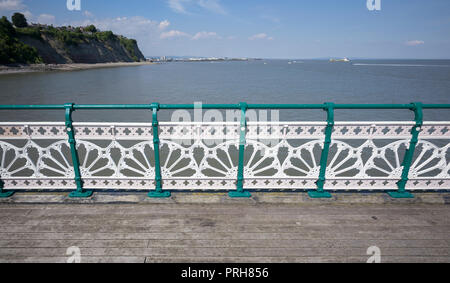Bunt lackierte gusseiserne Balustrade und Geländer mit traditionellen Muster am Rand von Pier, Penarth, South Wales, mit Küste hinter Stockfoto