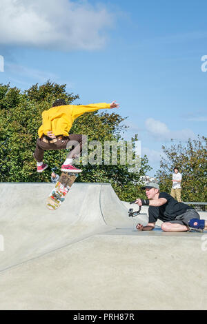 Ein Skateboarder gefilmt wird eine Antenne Trick an konkreten Wellen Skateboard Park in Newquay in Cornwall. Stockfoto