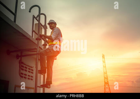 Ingenieur Techniker an der Leiter arbeiten Strom Kabel line Sonnenuntergang Hintergrund zu beheben Stockfoto