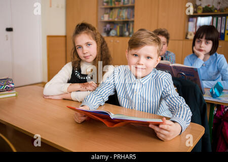 In der Ukraine. Kiew. Mai 5, 2018. Junior School, College. Paar zwei Kinder kaukasischer Nationalität, Schüler, Schule, Schreibtisch Schule klasse Zimmer sitzen. Auf tisch Bücher Stockfoto