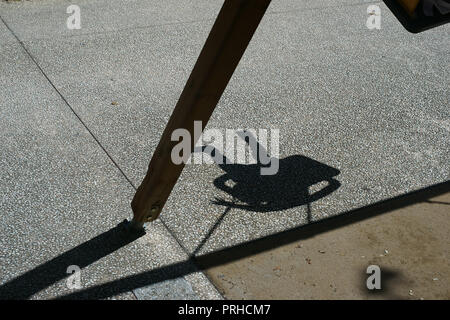 Ein Schatten, den ein Kind auf einer Schaukel Stockfoto