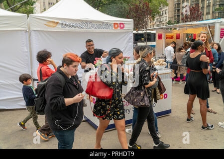 Menschenmassen am Dunkin' und Taube Zusammenarbeit Branding event in Flatiron Plaza in New York am Montag, 1. Oktober 2018. Die Besucher waren von dem kostenfreien Tassen Kaffee und Proben der von Unilever, Dove Marke trocken Shampoo behandelt. Offenbar, so die Veranstalter Frauen auf Dunkin' und trocken Shampoo ermöglicht Ihnen so schnell aufstehen und morgens laufen. Dunkin' Brands vor kurzem änderte ihren Namen ablegen moniker 'donuts' besser Rechnung zu tragen, dass 60 Prozent der Verkäufe sind Kaffee Getränke. (Â© Richard B. Levine) Stockfoto