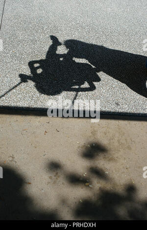 Ein Schatten, den ein Kind und seine Mutter auf einer Schaukel Stockfoto