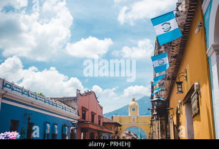 Guatemaltekischen Fahnen wehen bis zu den berühmten gelben Bogen von Santa Catalina in Antigua Guatemala an einem sonnigen Tag der Unabhängigkeit Stockfoto