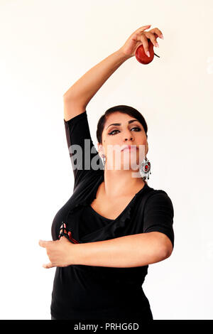 Junge Spanische gypsy woman dancing Flamenco mit braunen Kastagnetten in den Händen. Flamenco Tänzerin in schönen nationalen Kleid auf einem weißen Hintergrund. Spanien Stockfoto