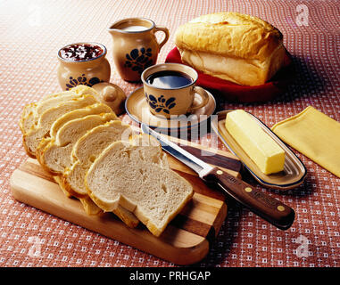 Noch immer leben von geschnittenem Brot, Butter, Kaffee, Milch, Marmelade, Messer und Schneidbrett auf einem Tisch Stockfoto