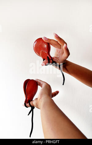 Spanischen Kastagnetten in den Händen auf weißem Hintergrund, aus der Nähe. Percussion Instrument in Flamenco, sevillanas Tanz in Spanien, isoliert, bis zu schließen. Stockfoto