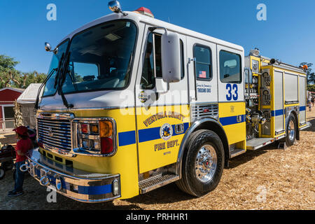 Moorpark, Kalifornien, USA - 30. September 2018: Nahaufnahme von gelben und weißen Ventura County Fire Departement Lkw unter blauem Himmel und auf gelbes Stroh. Stockfoto