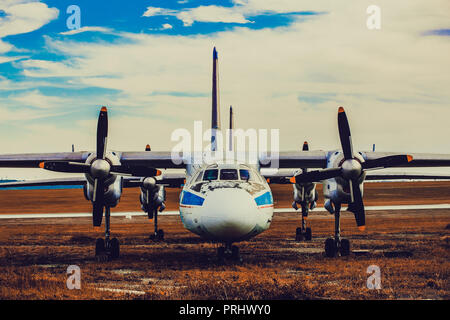 Eine alte Cargo propeller Flugzeug steht auf einem Parkplatz in der Nähe der Start- und Landebahn, getönten Hintergrundbild Stockfoto