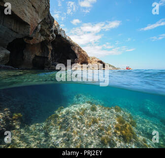 Höhle am Meer mit felsigen Boden unter Wasser, geteilte Ansicht oberhalb und unterhalb der Wasseroberfläche, Mittelmeer, Costa Blanca, Javea, Valencia, Spanien Stockfoto