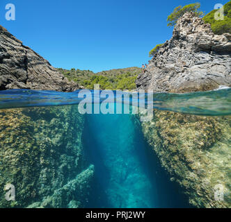 Eine Passage zwischen den Felsen an der Küste, geteilte Ansicht oberhalb und unterhalb der Wasseroberfläche, Spanien, Mittelmeer, Costa Brava, Roses, Katalonien, Girona Stockfoto