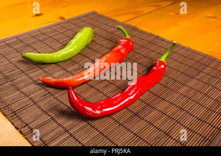 Eine bunte Mischung der frischesten und heißesten chili peppers auf einem Bambus Matte, Nahaufnahme Stockfoto