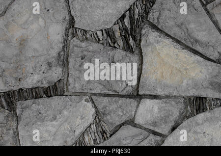 Wand mit Brocken von Steinen in geometrischen Formen, natürliche dekorativen Hintergrund. Stockfoto