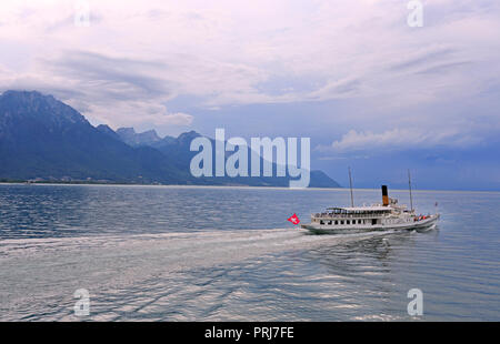 Kreuzfahrt Dampfgarer am Genfer See vor dem Hintergrund der schönen Berge und Spiegelbild im Wasser vor dem Sturm, Schweiz Stockfoto