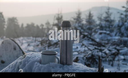 Heißer Kaffee Thermoskanne auf Schnee stumpf Stockfoto
