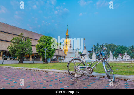 Ein Fahrrad von Buddha Verehrer und der goldene Turm oder Pagode von Wat Suan Dok im Hintergrund. Stockfoto
