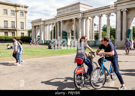 London England, Großbritannien, Hyde Park Corner, Decimus Burtons Ionischer Bildschirm, Tor, Säulen, Mann Männer männlich, Frau weibliche Frauen, Paar, Radfahrer, Fahrrad Fahrräder Fahrrad Stockfoto