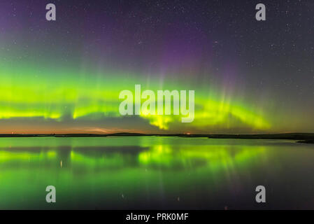Die Nordlichter und ein schwaches Display von Nachtleuchtende Wolken (niedrig am Horizont) über die Gewässer von Crawling See im südlichen Alberta, auf Juni 24./25. Stockfoto