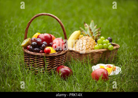 Sortierte Obst in Körben für Picknick auf Gras. Stockfoto